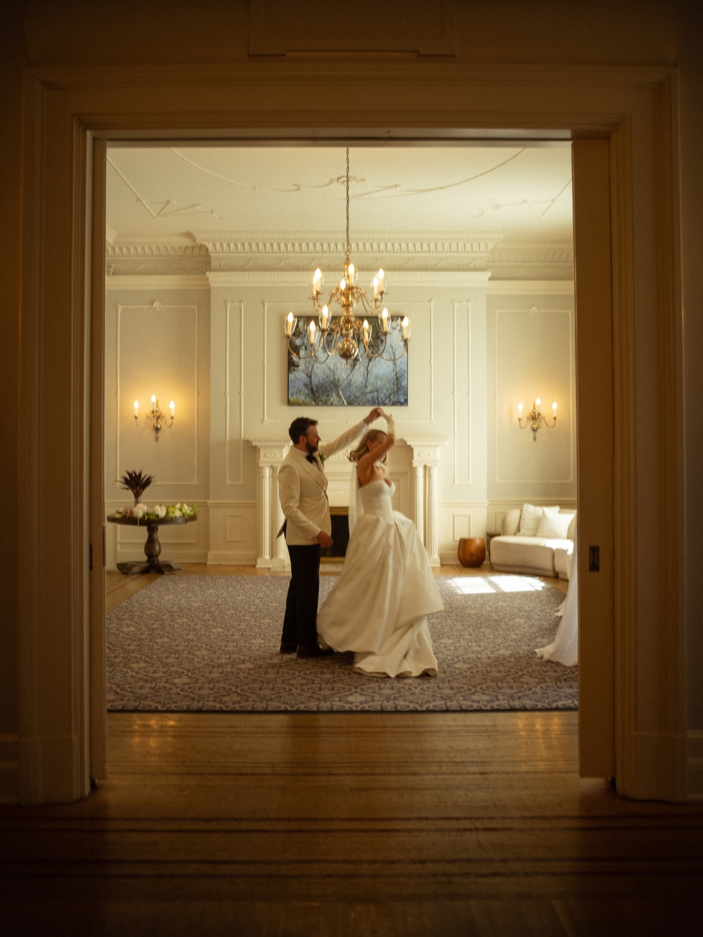 Newlyweds dancing beneath a chandelier at their wedding